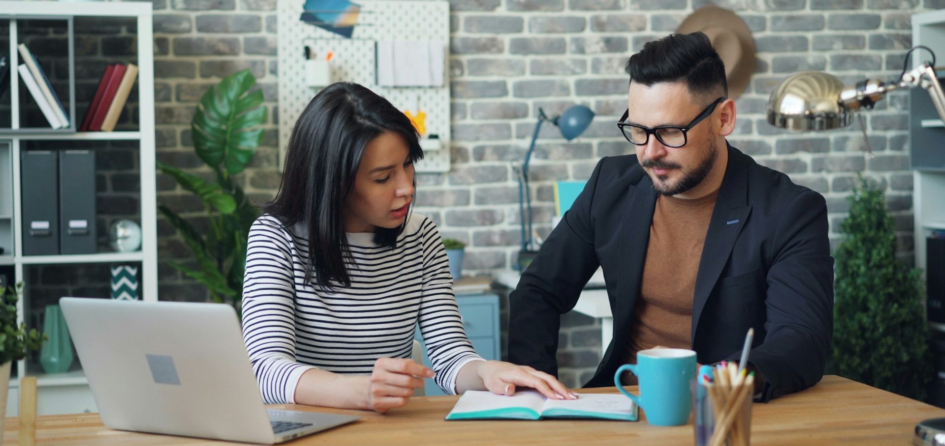 Dos personas revisan documentos juntos en un entorno de oficina moderno.